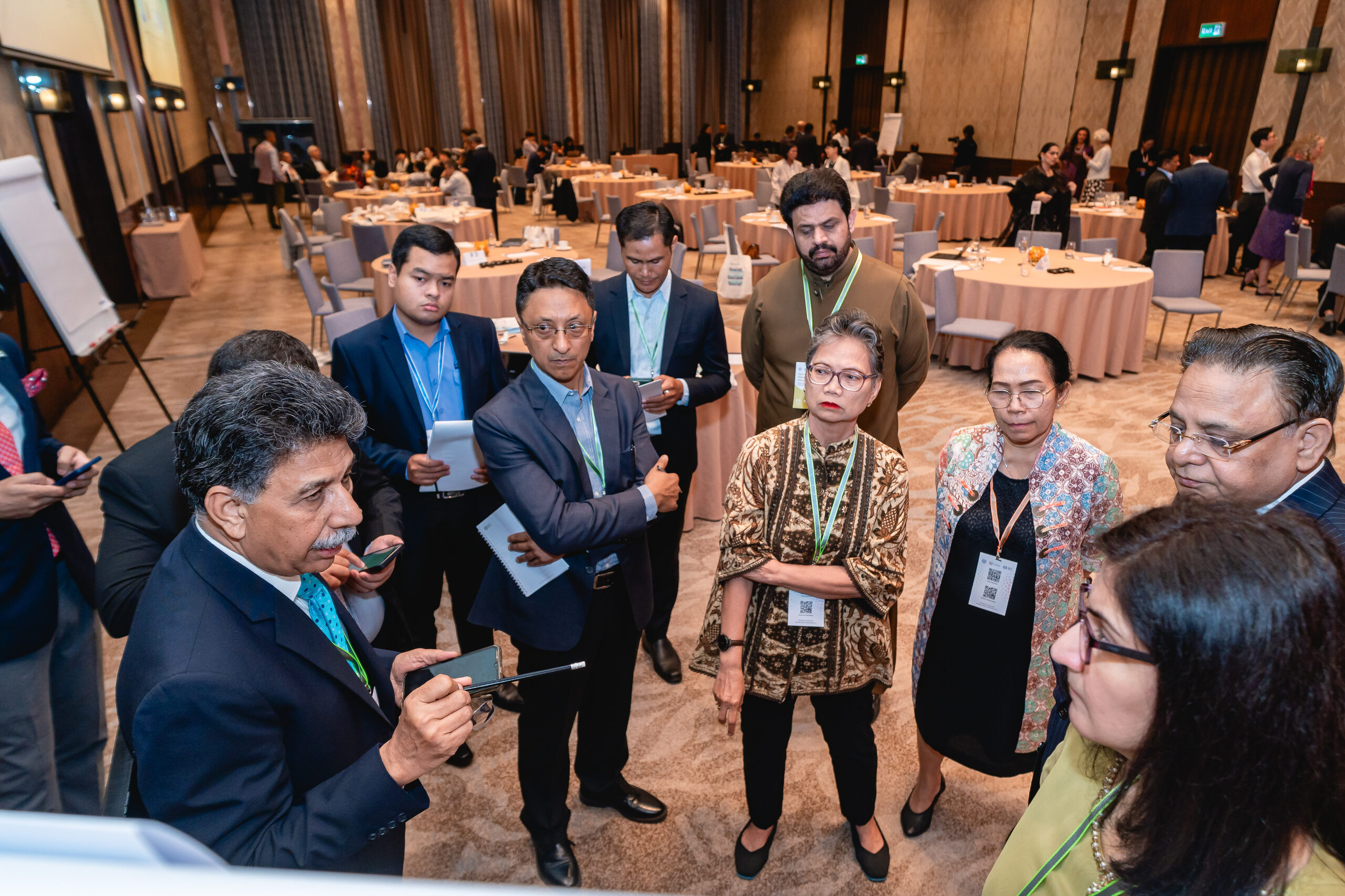 A group of workshop delegates standing in a circle in discussion around a facilitator