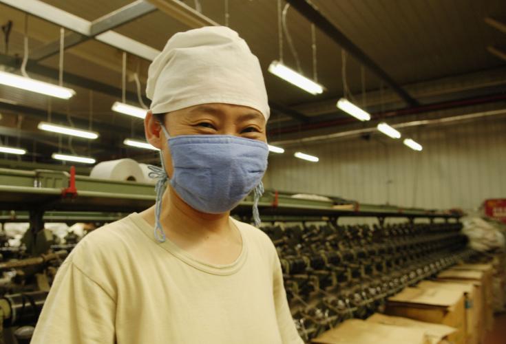 Asian man wearing mask while at work.