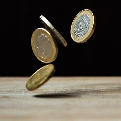 Euro coins on brown wood.