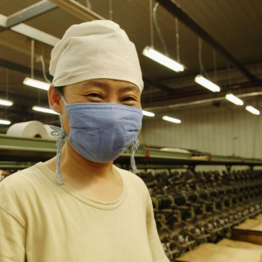 Asian man wearing mask while at work.