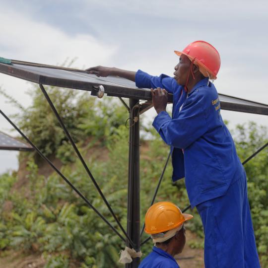 Two men installing solar panels.