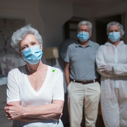 Photo of two older persons and one young female adult wearing face masks.