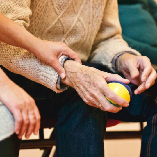 Older persons holding a stress ball