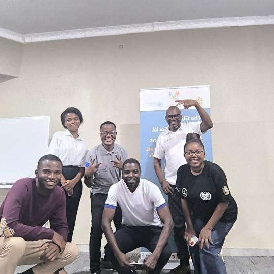People smiling in front of a banner
