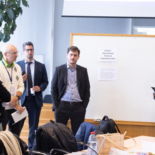 Men standing around a white board