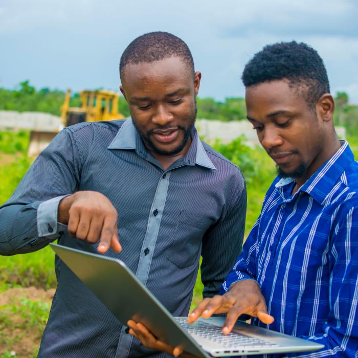 Two young men discussing over computer