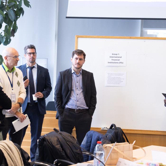 Men standing around a white board