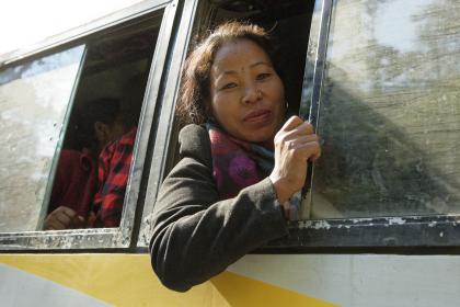 Everyday life, road transport - Portrait of a woman looking through the window of a bus going to Kathmandu, Dolakha district, area affected by the 2015 earthquake.  