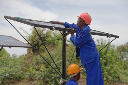 Two men installing solar panels.
