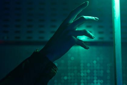 Person's Hand Reaching Out To A Light