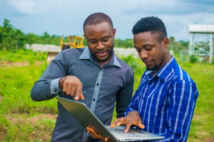 Two young men discussing over computer