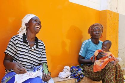 Women and a baby sitting together in rural Africa