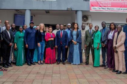 Women and men standing together in front of a government building
