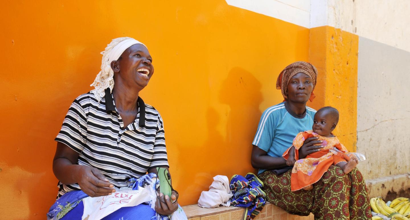 Women and a baby sitting together in rural Africa