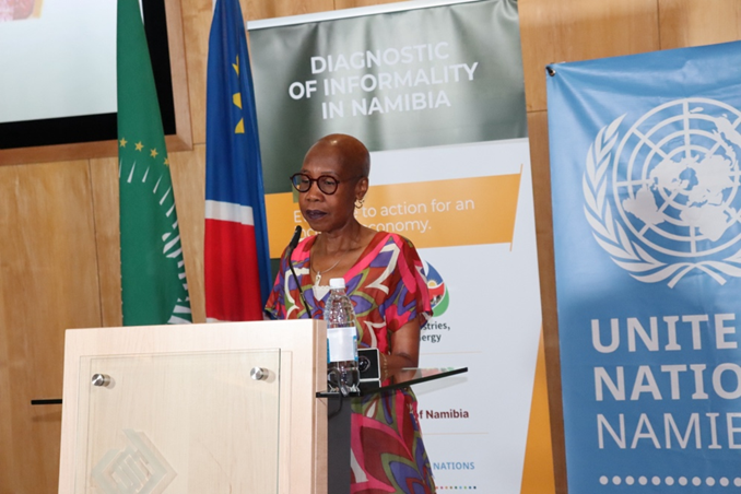 Woman speaking at an event, behind a podium