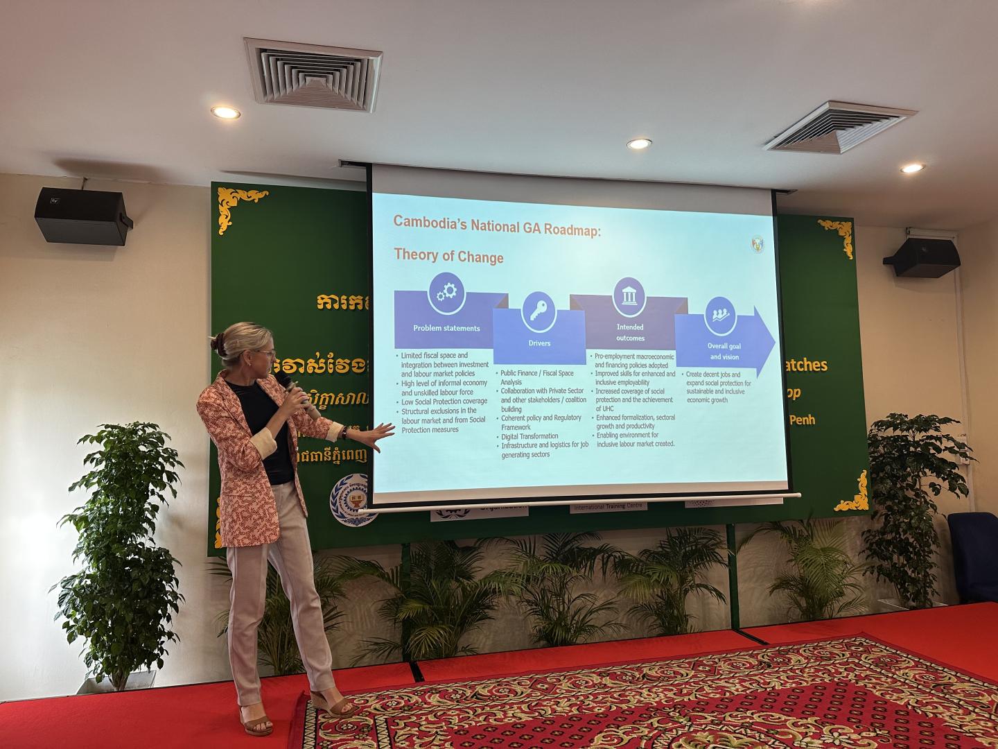 A woman presenting a slide on screen