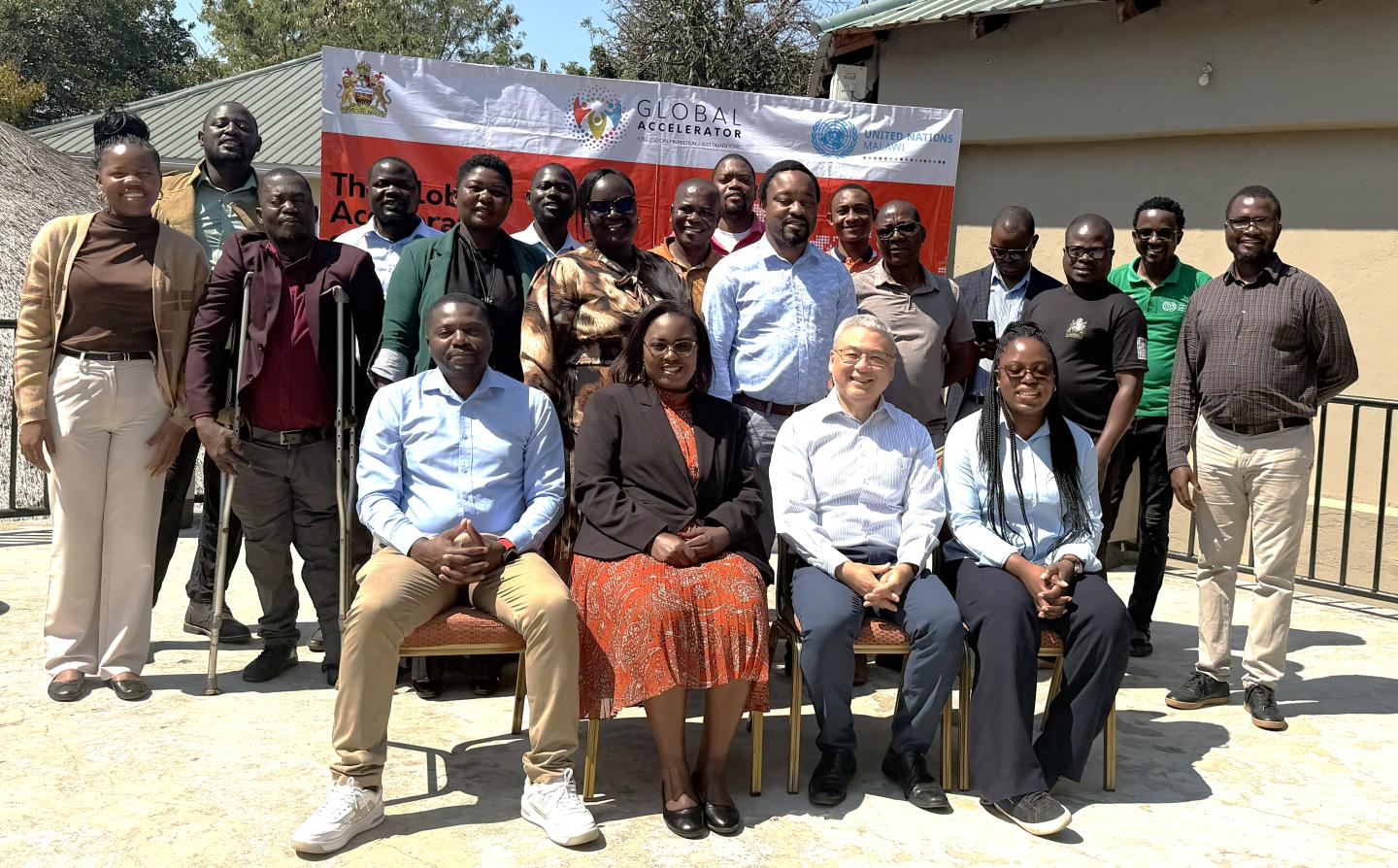 Group photo of women and men sitting outside