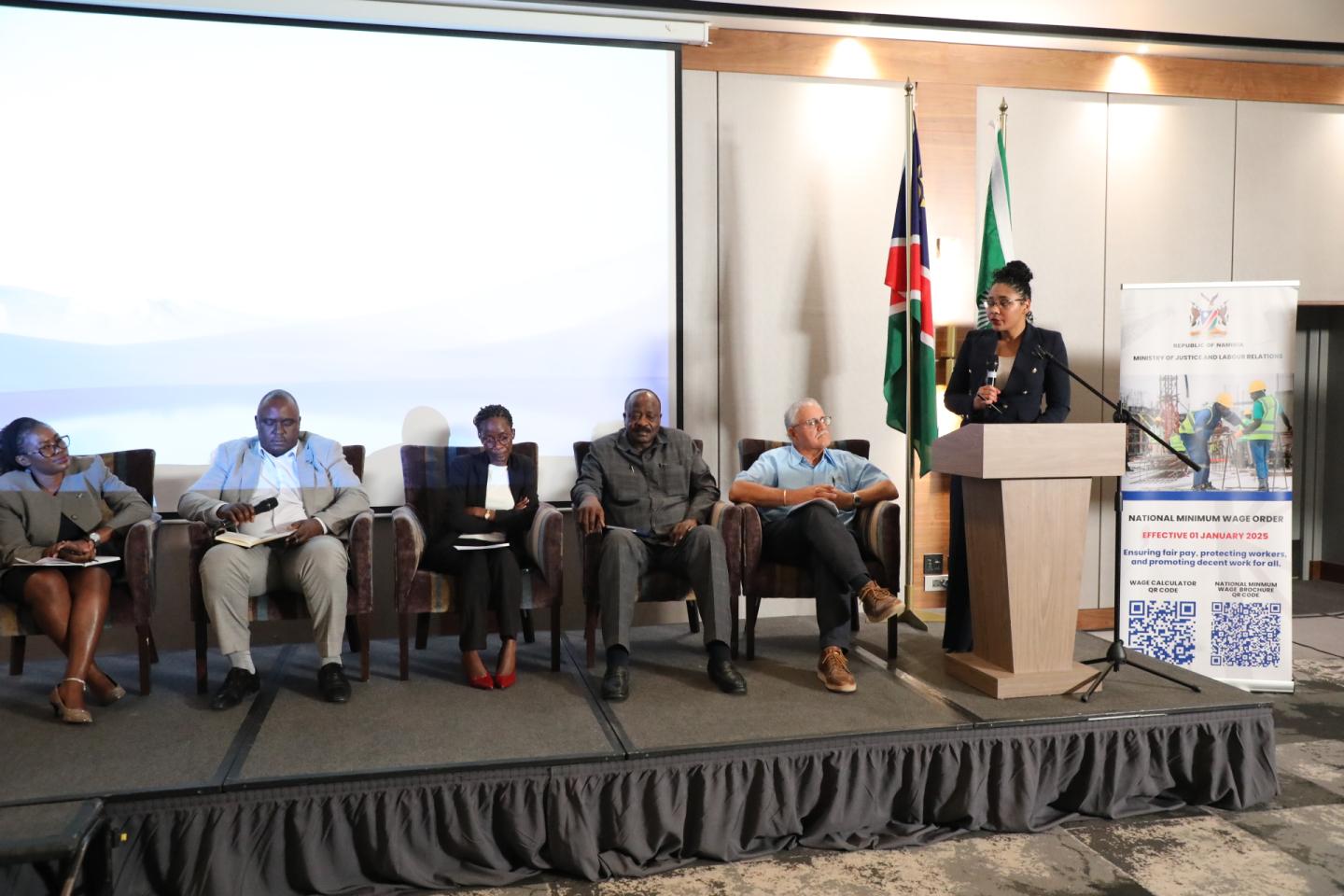 Women and men on a dais at an event